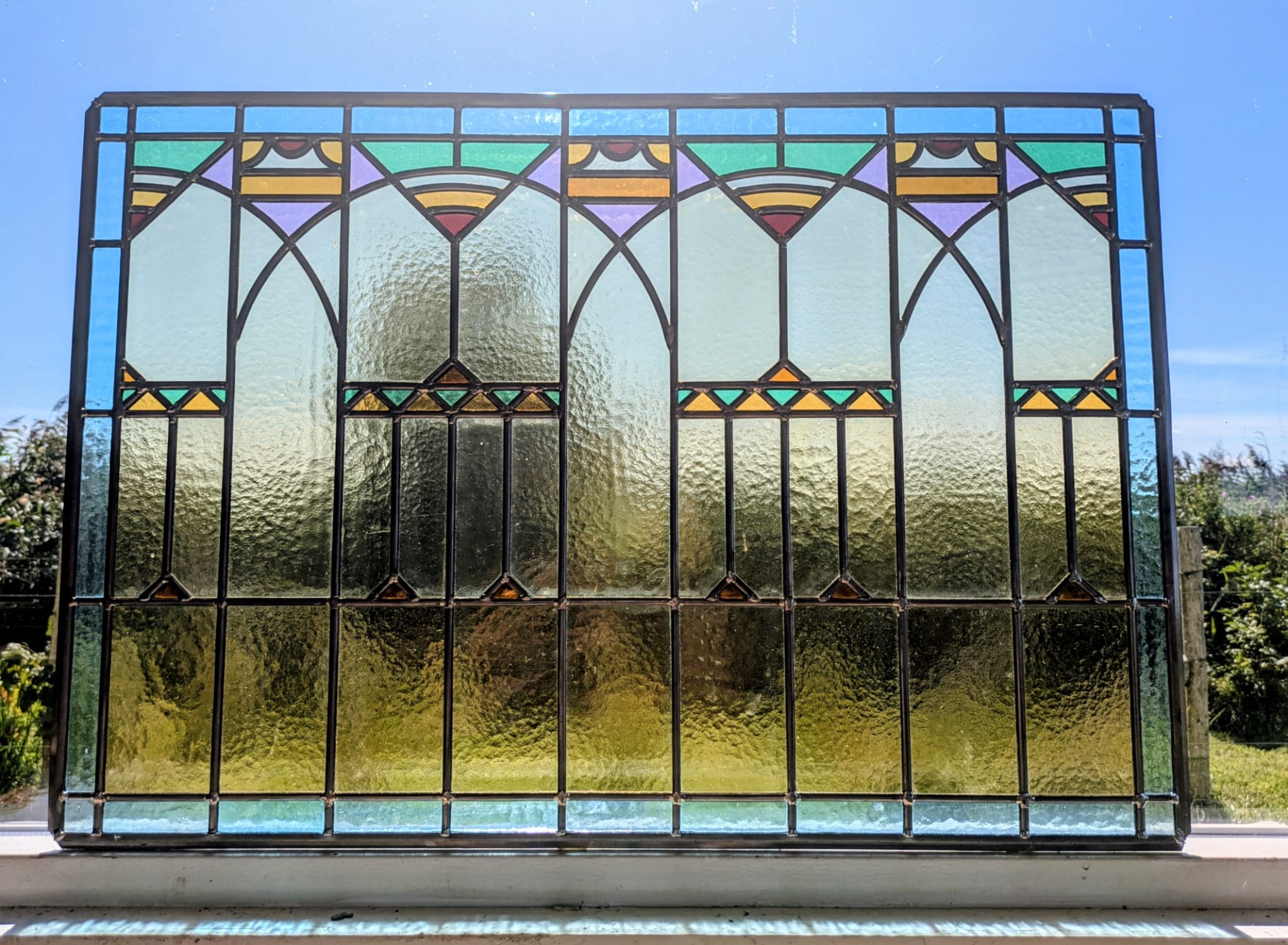 Glas-in-lood raam in art-decostijl tegen de lucht